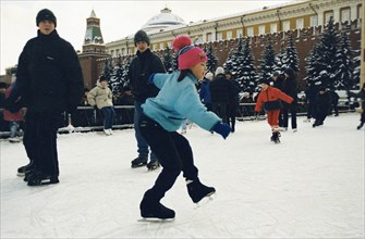 Children ice skating in a skating rink in red square, moscow, january 2001.
