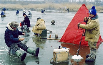 Men ice fishing in the belgorod region of russia, march 2001.