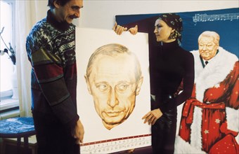 Victoria timofeyeva and dmitry vrubel with a calendar they produced together depicting 'the twelve moods of president putin' at the moscow modern art gallery, december 2001.