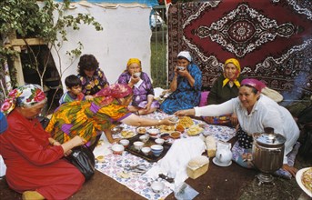 A bashkir family eating lunch and drinking tea in their back yard in the village of muratshino, bashkiria, russia.