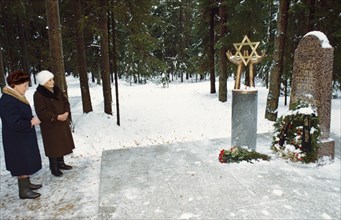 Two women visiting a memorial to jews that were executed during stalin's reign, st, petersburg, russia.
