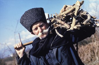 Abhasian elder, temyr vanacha, who claims to be 118 years old, collecting firewood in abhasia, georgia.