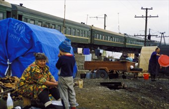 Chechen refugees outside the train they live in at the sleptsovskaya railway terminal, ingushetia, russia, november 1999.