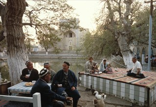 a tea house near the old mosque of lyabi-huaz (in the background) in bukhara, uzbekistan, 1990s.
