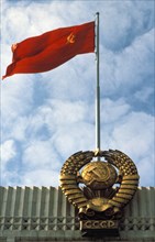 Flag and national emblem of the soviet union on a government building in moscow, ussr, 1990.