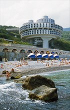People sunning themselves on a pebble beach at a resort and health spa on the black sea in the crimea, ukraine.