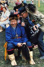 A folk performer and a photographer during the yakut folk festival, 'ysyakh', siberia, russia.