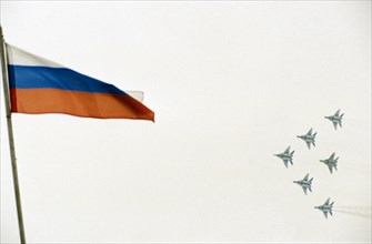 Su-27 fighter jet planes flying in formation with the flag of the russian federation in the foreground during the maks international air show, moscow region, august, 2001.
