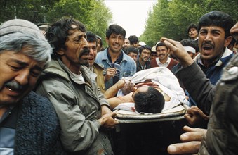 People carrying a man killed during a clash between government and opposition forces in dushanbe, tajikistan, may 1992.