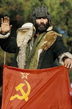 A pro-government fighter with a flag of the ex-soviet union (ussr) near kumsangir, tajikistan, january 1993.