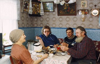 The dorogovichev family sitting down for a meal in their home in novgorod, russia.