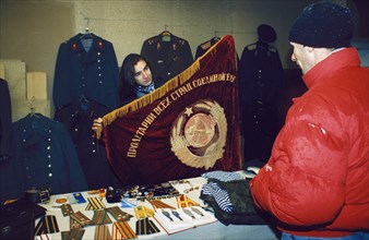 A woman selling soviet souvenirs at the outdoor market (vernissazh) in izmailovo park, moscow, russia, 1990s.