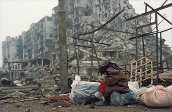 A chechen woman, one of thousands of homeless people who live among the ruins of buildings destroyed by russian shelling, grozny, chechnya, 1996.