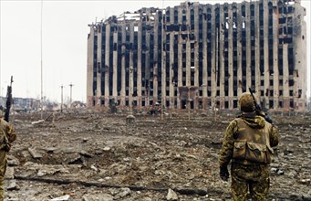 A russian interior ministry soldier looking at the ruins of the presidential palace in grozny, chechnya which was destroyed by russian shelling, february 1995.