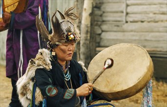 A tuvan shaman woman with drum, communing with spirits, tuva, russia.