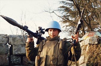A russian un peacekeeper in georgia holding an rpg and a machinegun during the conflict between georgia and abkhazia, february 2003.