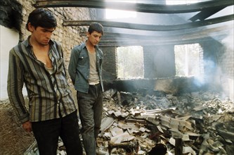 Two tajik men inside a house that was destroyed during fighting at the budenny state farm in kurgan-tyube, tajikistan, september 1992.