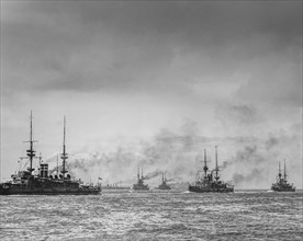Historic black and white image of ships on the ocean under a cloudy sky