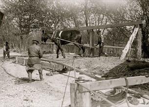 African American drilling a well with a horse on a turnstile