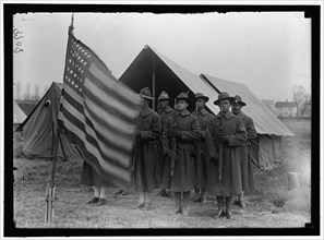 African American soldiers present arms to the Stars & Stripes