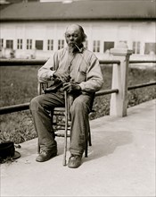 Ex-Slave - Man seated with pipe in 1920