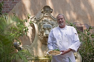 Chef  holds a plate of Fried Green Tomatoes
