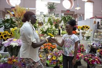 Mother gives child a flower in flower store