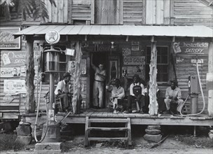 African American and a white store owner on the Porch of a country store