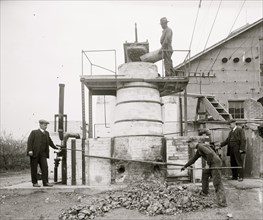 African American worker on Machine for extracting acid from phosphate