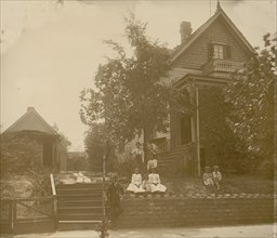 African American family posed on porch of house