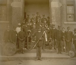 African American band posed on steps to brick building