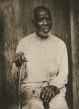 African American man hand holding cane, left hand on lap