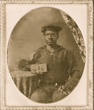 Sailor with cigar in hand holding a double case image of confederate soldiers