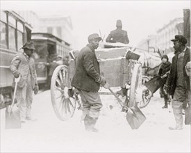 African American men shoveling snow in street, Washington, D.C