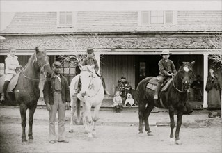 Afro-American enlisted man standing by three officers' children on horseback, Fort Verde, Arizona