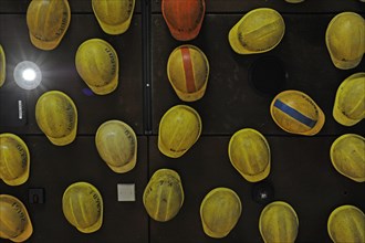 Workers helmets hanging from the ceiling.