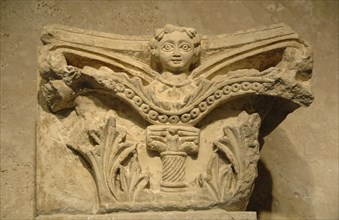 Capital decorated with a relief of a woman.