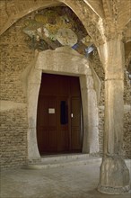 Spain. Santa Coloma de Cervello. Chuch of Colonia Guell by Gaudi (1852-1926). View of one of the entrances.