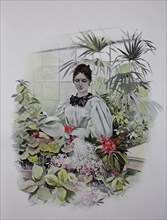 Woman pouring flowers in a greenhouse