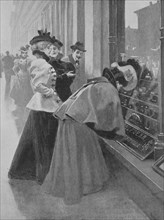 Women are standing in front of the window of a jeweler and are looking for Christmas wishes