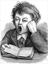 Boy yawns while reading  /  Junge gähnt bei Lesen