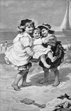 Three children playing on the North Sea beach