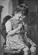 Little girl at the first attempts to knit