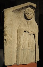 Funerary monument depicting a chubby child holding an apple.