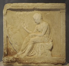 Base of a statue with reliefs. Boy seated, holding a crown in his hand.