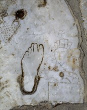 Marble slab engraved with the drawing of a woman, a left foot and a heart, indicative of the close presence of a public house or brothel.