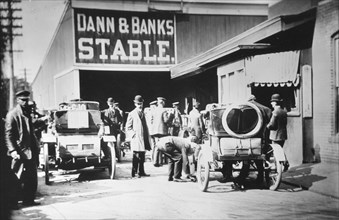 Early motorists purchase gasoline for their auttomobiles at a livery stable before 1912.