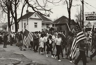 Participants, some carrying American flags, marching in the civil rights march from Selma to Montgomery, Alabama in 1965. Photo by Peter Pettus.