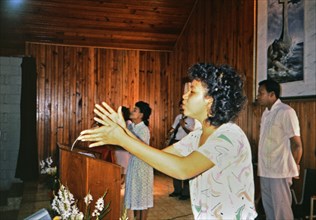 (R) Woman singing during a worship service in a small church in Honduras circa 1987.