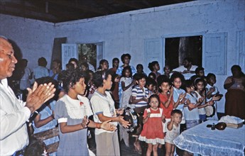 (R) Church members singing and clapping during a worship service at a small church in Honduras circa 1987.
